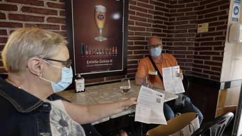 En imagen de archivo, dos clientes de un establecimiento hostelero de A Mariña mostrando el certificado covid para acceder al interior