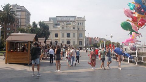 Personas paseando en la trigésima Fiesta de la Sidra Natural de Gijón ha comenzado este sábado con 22 participantes en un mercadillo de productos artesanos derivados de la manzana y se desarrollará hasta el próximo 29 de agosto