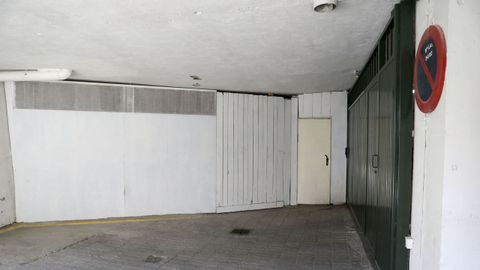 Tras la pared blanca, de madera, está el trastero, y el portalón verde es el del aparcamiento de los edificios 18 y 16, que tiene tres sótanos. Lo que se ve en la imagen en vía pública