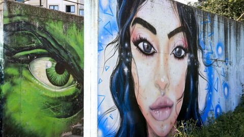 Miradas. Rúa do Hórreo, 2. Este gran mural que se ve en la imagen no es precisamente el que fue elegido en la plataforma de arte urbano porque el original se quedó debajo de esta nueva obra, que tampoco le a la zaga en calidad y reflexión social. La mirada amenazante del monstruo frente a la sensualidad y libertad de la belleza que está en primer plano.