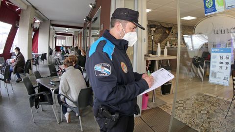 Un agente de la Policía Local de Rianxo, en una fotografía de archivo controlando el aforo de un local