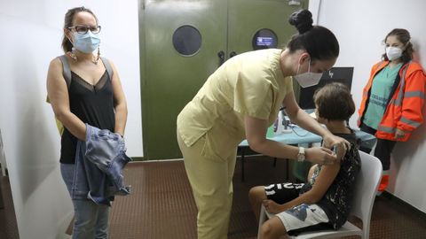 Un niño recibe la vacuna contra el covid-19 en el Campus Sur de Santiago de Compostela