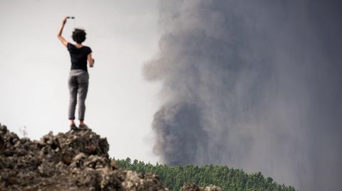 Una mujer observa el volcán