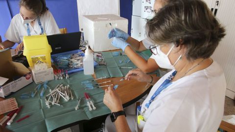 Varias sanitarias preparan dosis de las vacunas contra el covid en el centro de mayores de Laraxe, en Fene