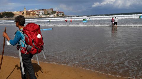 Una mujer pasea por la playa de San Lorenzo de Gijón