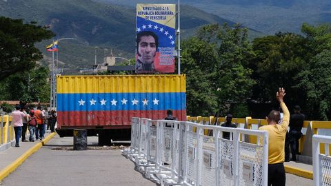 La gente pasa cerca del contenedor que bloqueaba el puente fronterizo entre Venezuela y Colombia.