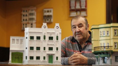 Carlos Macías, fotografiado entre su maqueta de la fábrica Hispania, la más reciente, y otra del edificio del bar Galerna, donde exhibe sus creaciones