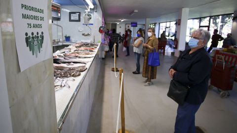 Vecinas de As Pontes aguardando su turno en un puesto del mercado municipal.