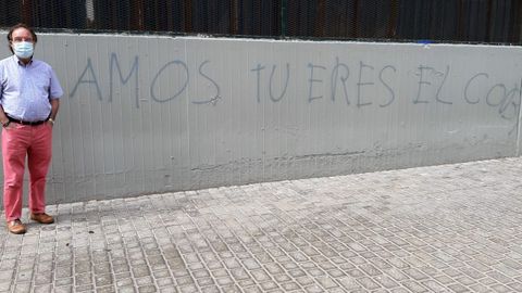 Amós García Rojas, al lado de una pintada con la que intentan ofenderle