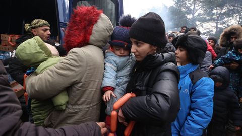 Migrantes varados en la frontera recibe ayuda de la Cruz Roja bielorrusa.