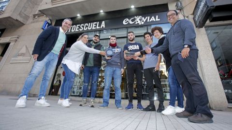 Seis jóvenes que aspiran a obtener el permiso para conducir camiones en Pontevedra, junto a sus monitores, en la autoescuela Ecovial, y con dos tacógrafos del transporte en la mano
