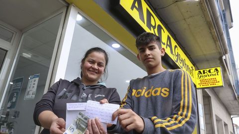 Lourdes Céspedes y su hijo Ezequiel Aponte enseñan el billete y la carta recibida en Arca Gourmet. Allí sirven desde desayunos calientes para los peregrinos extranjeros, como revuelto de huevos y tortilla de patatas, hasta un buen café, «pan tumaca», o yogures artesanales, entre otras muchas cosas.