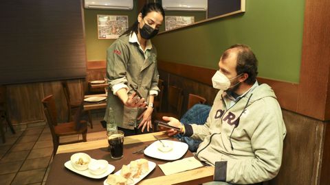La propietaria del restaurante Los Caracoles de Santiago le pide el certificado covid a un cliente