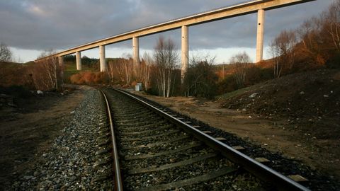 La línea ferroviaria convencional, con un viaducto del eje de alta velocidad Ourense-Santiago. Ambos trazados están segregados y el cambio de ancho no afectaría a las mercancías