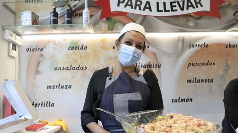 Una de las empleadas de la nueva tienda de comida casera para llevar de la estación de servicio Santa Lucía muestra uno de sus platos estrella, el salpicón de marisco. En principio, y a expensas de reajustes horarios en función de la demanda, el despacho (en Santiago de Chile, 15) funcionará de 10 a 15 y de 18 a 21 horas de lunes a sábado y los domingos únicamente en el horario matutino.