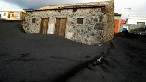 Una casa sepultada por la ceniza del volcán Cumbre Vieja en el barrio de Las Manchas