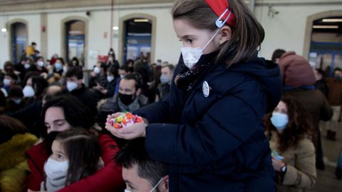 Una niña, con los caramelos que le acaban de dar los Reyes Magos en la estación de Monforte