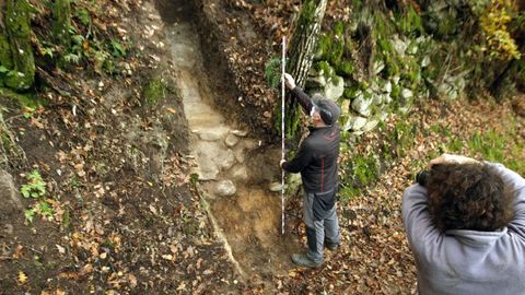 Los arqueólogos Andrés Currás y Carlos Aguilera examinan un corte realizado en una antigua terraza vitícola de O Preguntoiro del que se extrajeron diversas muestras que se utilizarán para precisar la antigüedad de la estructura mediante dataciones por carbono 14