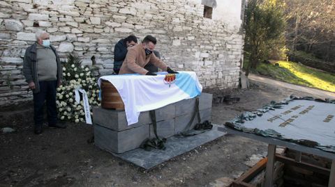 Uxío Novo, fillo de Novoneyra, prepara a bandeira que cubría o cadaleito antes de retirala para proceder a introducilo na sepultura