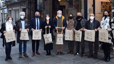 Presentación de las bolsas ilustradas con el dibujo de Ramón Conde que el Casino repartió entre comerciantes y libreros. En la foto, de izquierda a derecha: Varela, Mouriño, García, Rosón, Seijas, Lorenzo, Conde, Rueda y Alvite.