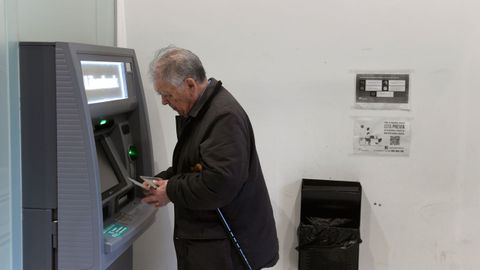 Un hombre de avanzada edad, saca dinero de un calero automtico de una entidad bancaria en el centro de Oviedo