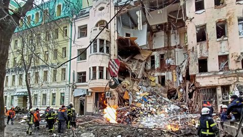 Rescatistas trabajan junto a un edificio dañado por un ataque aéreo, mientras continúa el ataque de Rusia a Ucrania, en el centro de Kharkiv