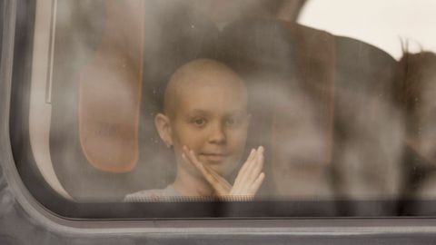 Una nia enferma de cncer, que huy de la invasin de Ucrania, hace gestos desde el interior de un tren operado por la Cruz Roja polaca y reservado para personas que necesitan atencin mdica.