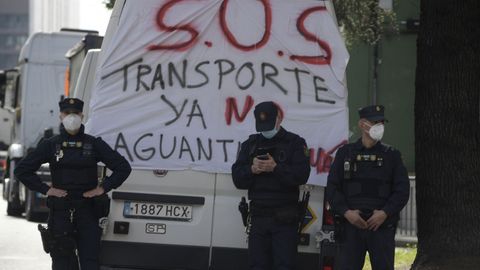 Policas junto a una pancarta en las protestas de colectivos del transporte y ganaderos en Oviedo