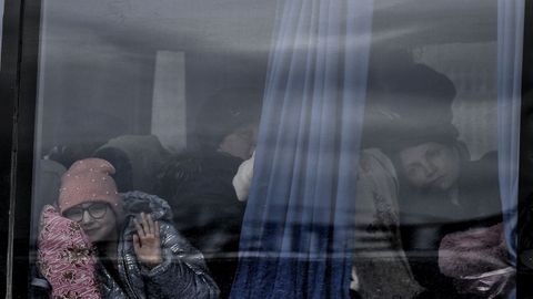 Una niña saluda desde un autobús en el que ha llegado a Zaporiya, ciudad a la que llegan ciudadanos de Mariúpol con el objetivo de llegar a Leópolis para salir por Polonia