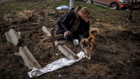 Serhii Lahovskyi, de 26 años, llora junto a la tumba de su amigo Ihor Lytvynenko, quien según los residentes fue asesinado por soldados rusos en Bucha.