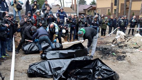 Las fuerzas del orden colocan en bolsas para restos humanos los cuerpos de civiles asesinados por los ocupantes rusos, que intentaron quemarlos para ocultar sus crímenes.