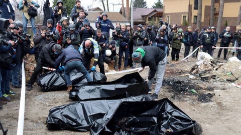 Las fuerzas del orden colocan en bolsas para restos humanos los cuerpos de civiles asesinados por los ocupantes rusos, que intentaron quemarlos para ocultar sus crmenes.