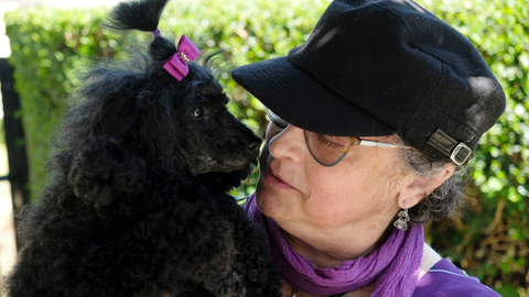 Pilar acompañada de su perro que lleva un lazo morado, el color elegido para la lucha contra el lupus.