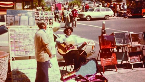 O escritor en San Francisco, cun músico da rúa