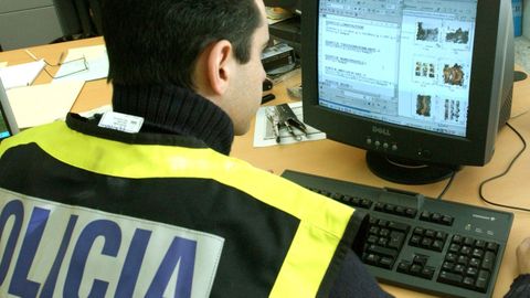 Imagen de archivo de un agente inspeccionando un ordenador 