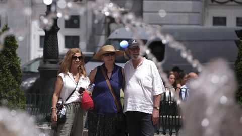 Unos turistas se fotografan delante de la fuente de La Escandalera, al lado del Teatro Campoamor de Oviedo