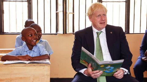 VIAJE A RUANDA. El presidente ruandés, Paul Kagame, y Boris Johnson elogiaron en Kigali ?donde se celebra la 26.ª reunión de jefes de Gobierno de la Commonwealth? el polémico plan del Reino Unido para enviar a los solicitantes de asilo a Ruanda. En la foto, el «premier» visitando un colegio.