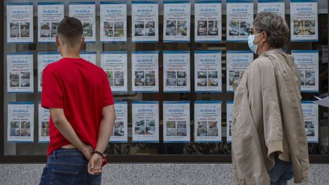 Imagen de archivo de un joven mirando el escaparate de una inmobiliaria en Vilagarca