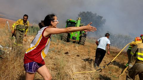 Una mujer reclama a los bomberos que atiendan una zona que est ardiendo en la localidad zamorana de Tbara