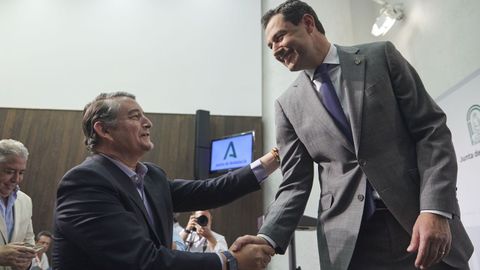 Juanma Moreno saluda al nuevo consejero de la Presidencia, Antonio Sanz, tras la rueda de prensa para anunciar la conformación del nuevo Gobierno andaluz