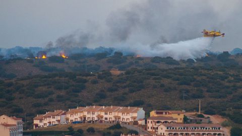 Efectivos de extinción de incendios tratan de evitar que el fuego afecte a una urbanización de la zona de Las Lagunas de Ruidera, Ciudad Real