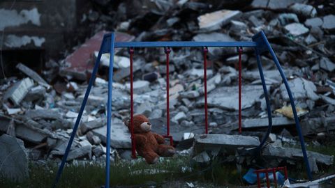 Un oso de peluche en un columpio de una zona residencial destruida por las tropas rusas, en Jrkov (Ucrania)