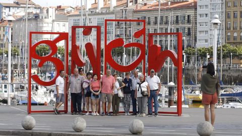 Turistas se fotografían en las  letronas  de Gijón