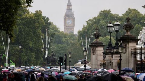 La lluvia no impidi a muchas personas acudir a rendir homenaje a la reina delante del palacio real.