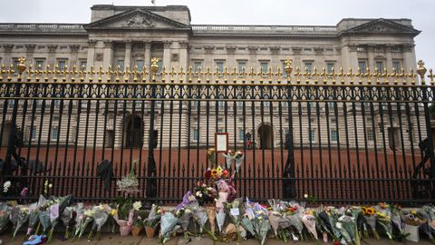 La verja del palacio de Buckingham, llena de ramos de flores.