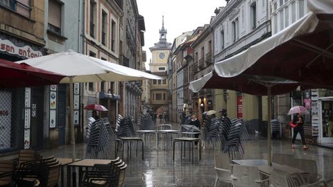 una de las terrazas del centro de Oviedo bajo la lluvia
