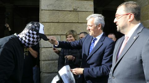 El presidente de la Xunta, Alfonso Rueda, acompañado de su homólogo de Asturias, Adrián Barcón, le pone la gorra al ajedrecista Rey Enigma, con quien coincidieron en el Obradoiro.