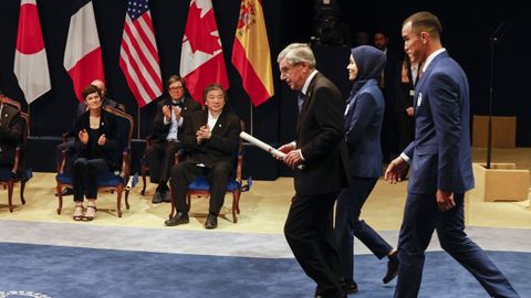 El presidente del Comité Olímpico Internacional, Thomas Bach, acompañado por el boxeador venezolano Eldric Sella Rodríguez y la ciclista afgana Masomah Ali Zada, competidores ambos en los JJOO de Tokyo 2020