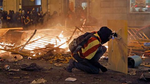 Un manifestante independentista se protege con una plancha de madura durante los disturbios que arrasaron Barcelona 