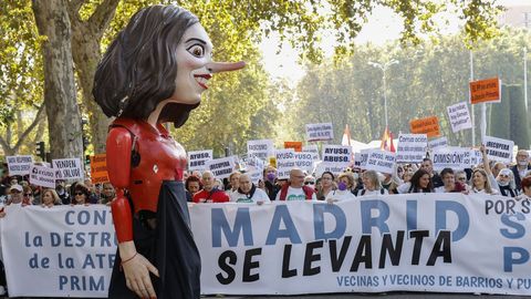 Un cabezudo con la efigie de Ayuso recorre el frente de la manifestación en defensa de la sanidad pública en Madrid.